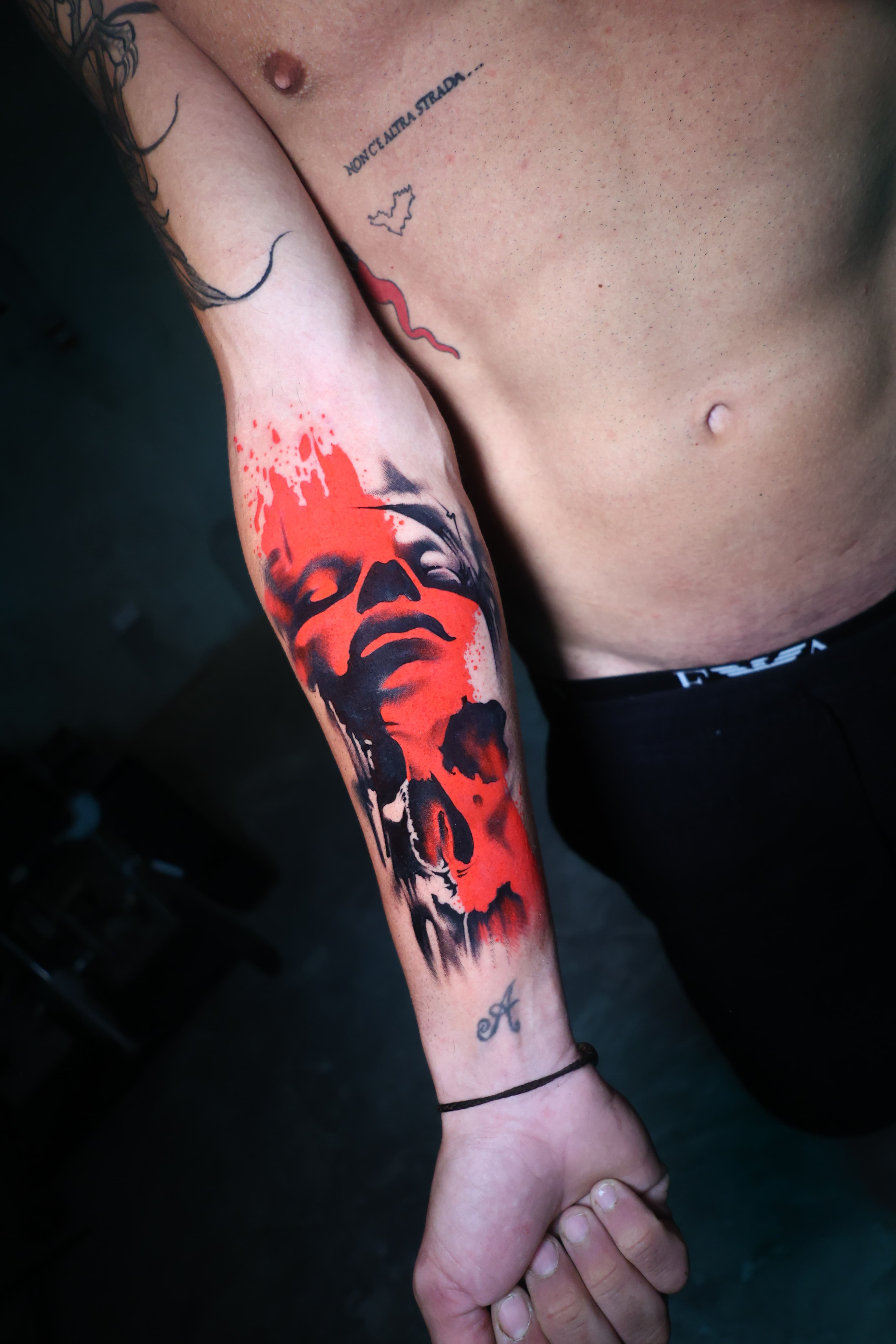 Red and black abstract portrait forearm tattoo by Riverón